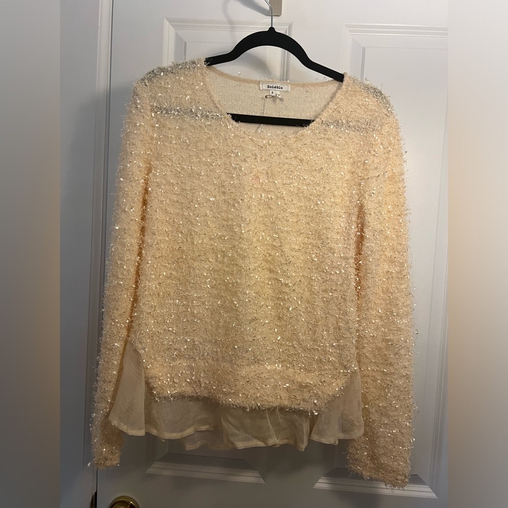 If fun cream long sleeve top with sheer feminine trim on the bottom